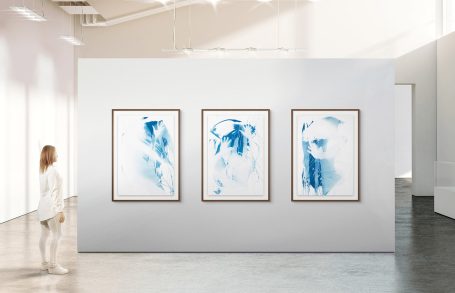 Weiße Galerie mit drei rahmenden blauen abstrakten Gemälden.